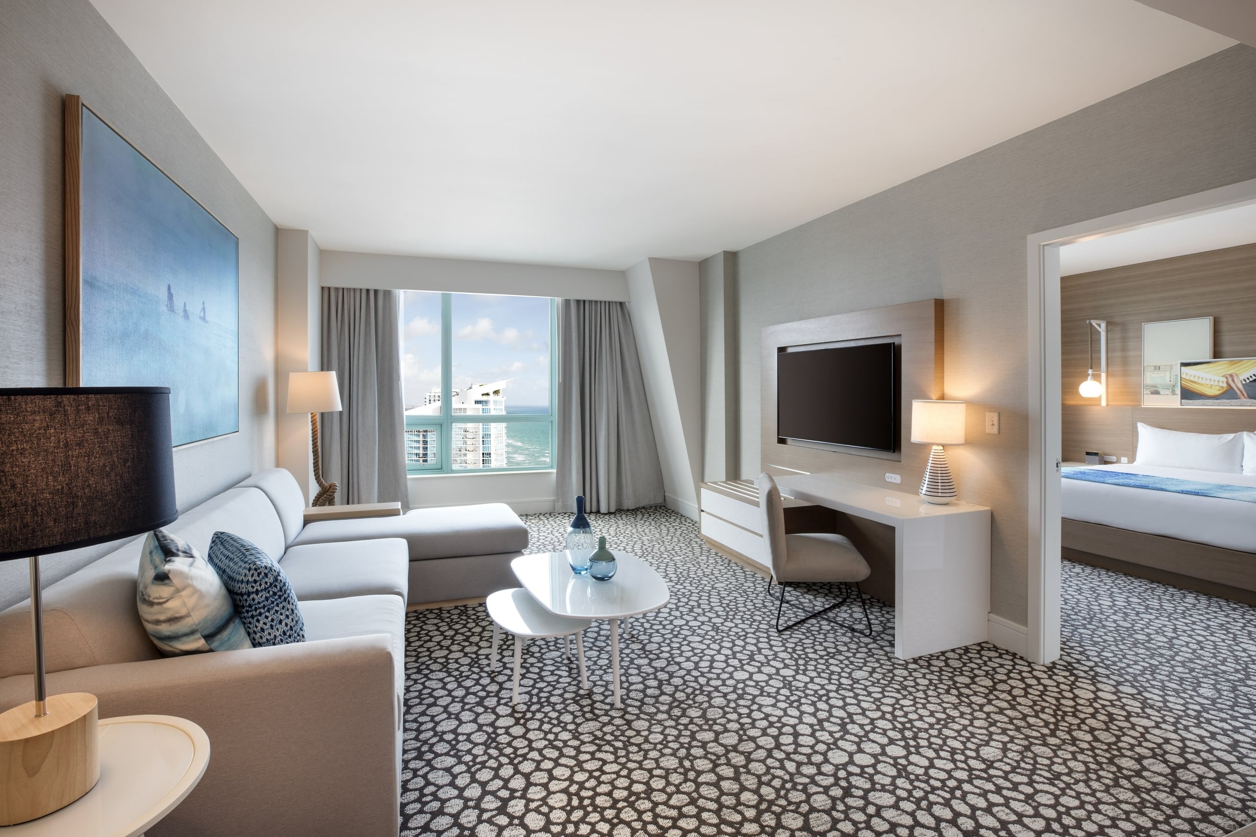 Diplomat Suite Living Room with a large sectional sofa, mounted TV and decor, with views of the resort outside
