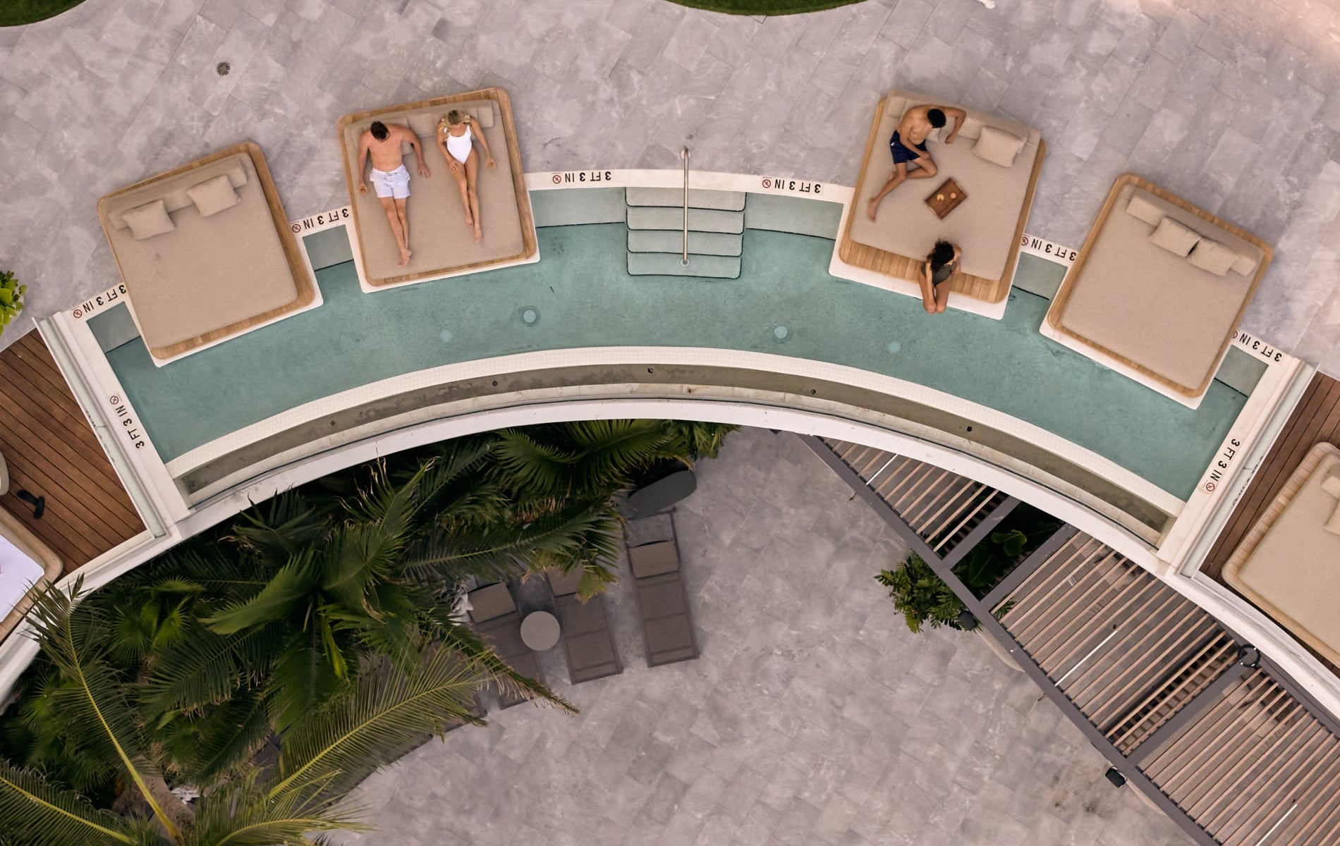 Aerial view of cabanas nestled into an curved wading pool