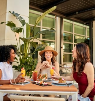 Three woman seated on an outdoor terrace for breakfast