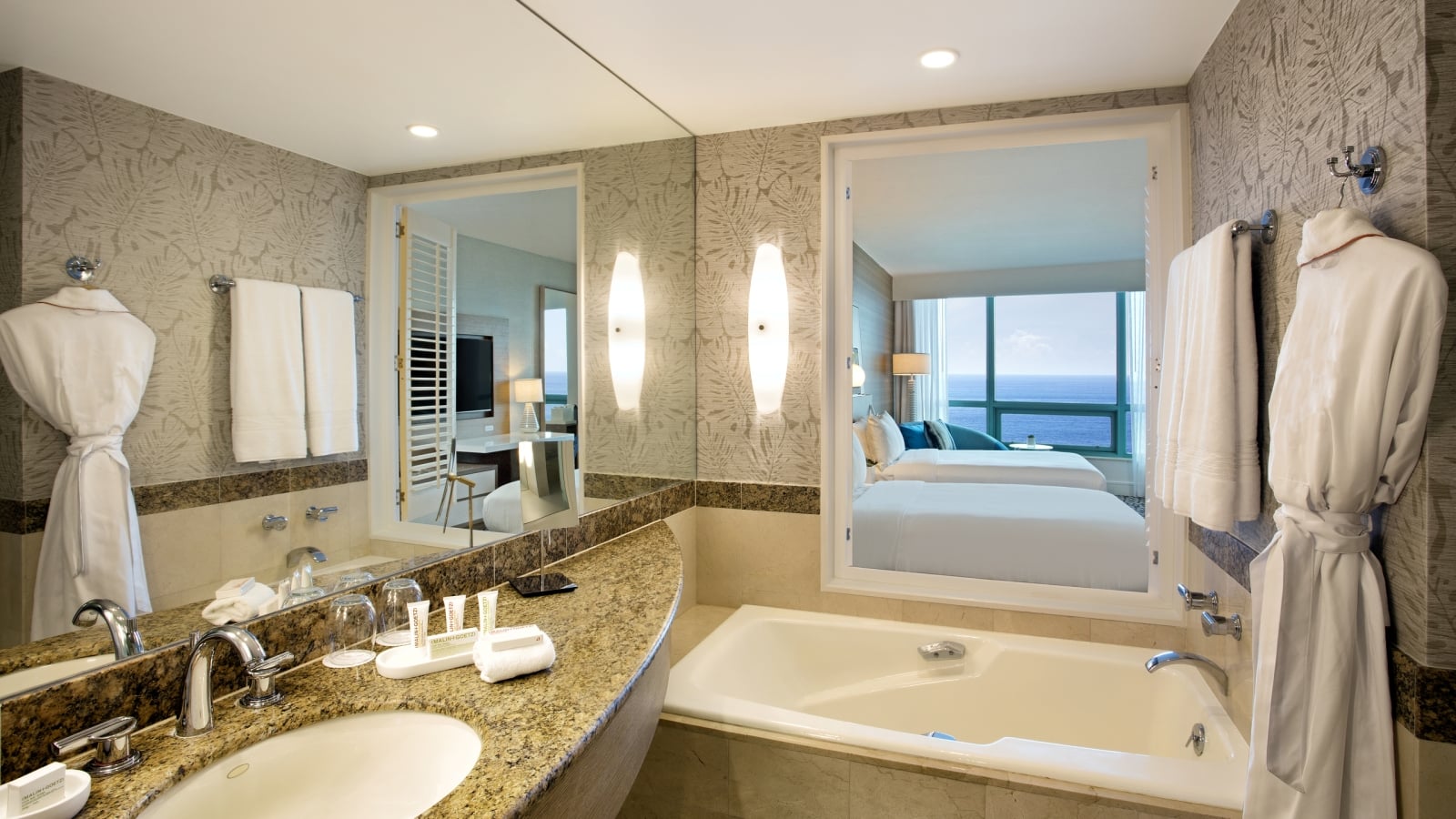 Superior Oceanview Double Bathroom featuring a deep bathtub and hanging white robe