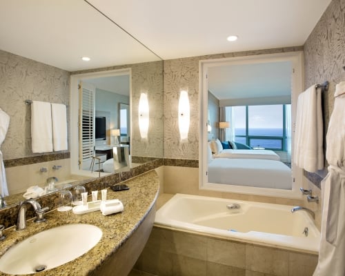 Superior Oceanview Double Bathroom featuring a deep bathtub and hanging white robe