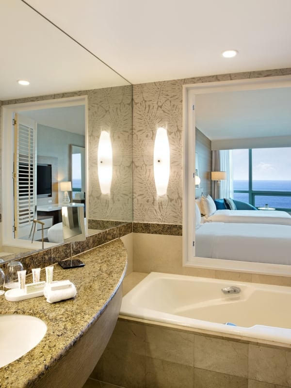 Superior Oceanview Double Bathroom featuring a deep bathtub and hanging white robe