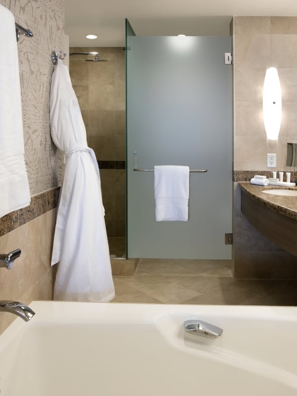 Guestroom Bathroom - Interior View featuring bathtub and white robe hanging on the wall