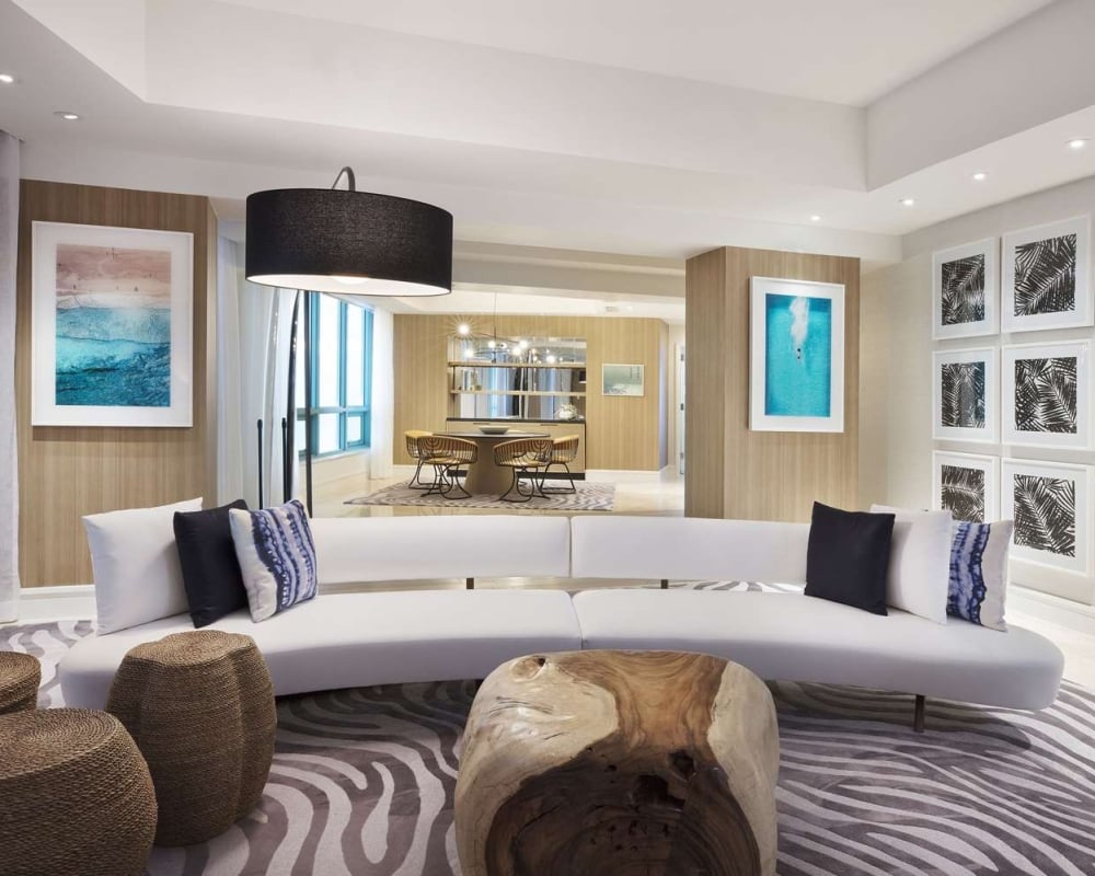 Presidential suite at The Diplomat Resort featuring a stylish living room with modern sofa, fauna oriented wall decor, and an overall relaxing ocean vibe