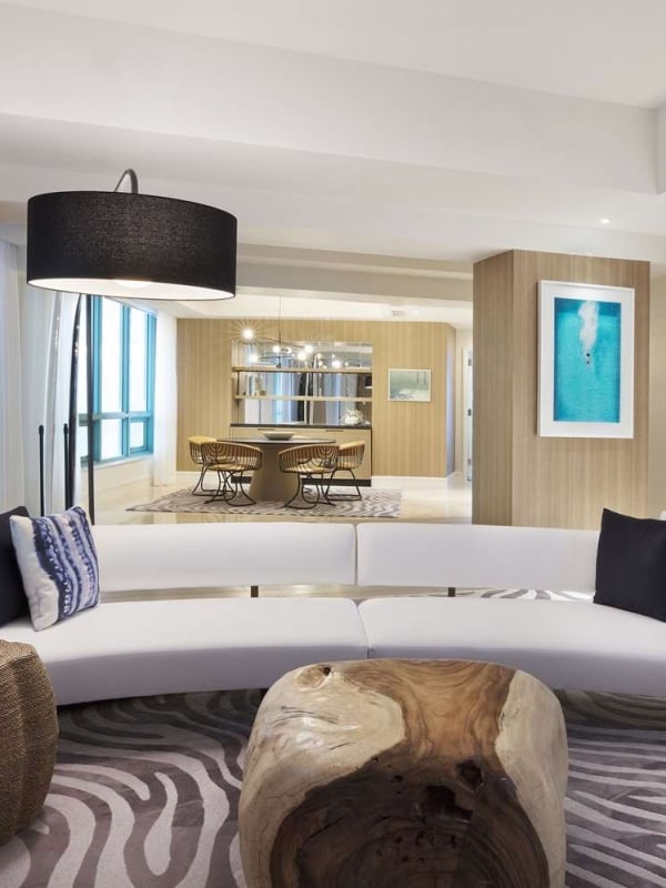 Presidential suite at The Diplomat Resort featuring a stylish living room with modern sofa, fauna oriented wall decor, and an overall relaxing ocean vibe