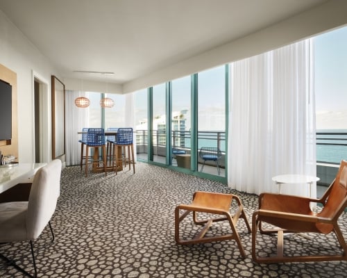 Oceanfront King Suite with floor to ceiling windows overlooking the patio and ocean beyond