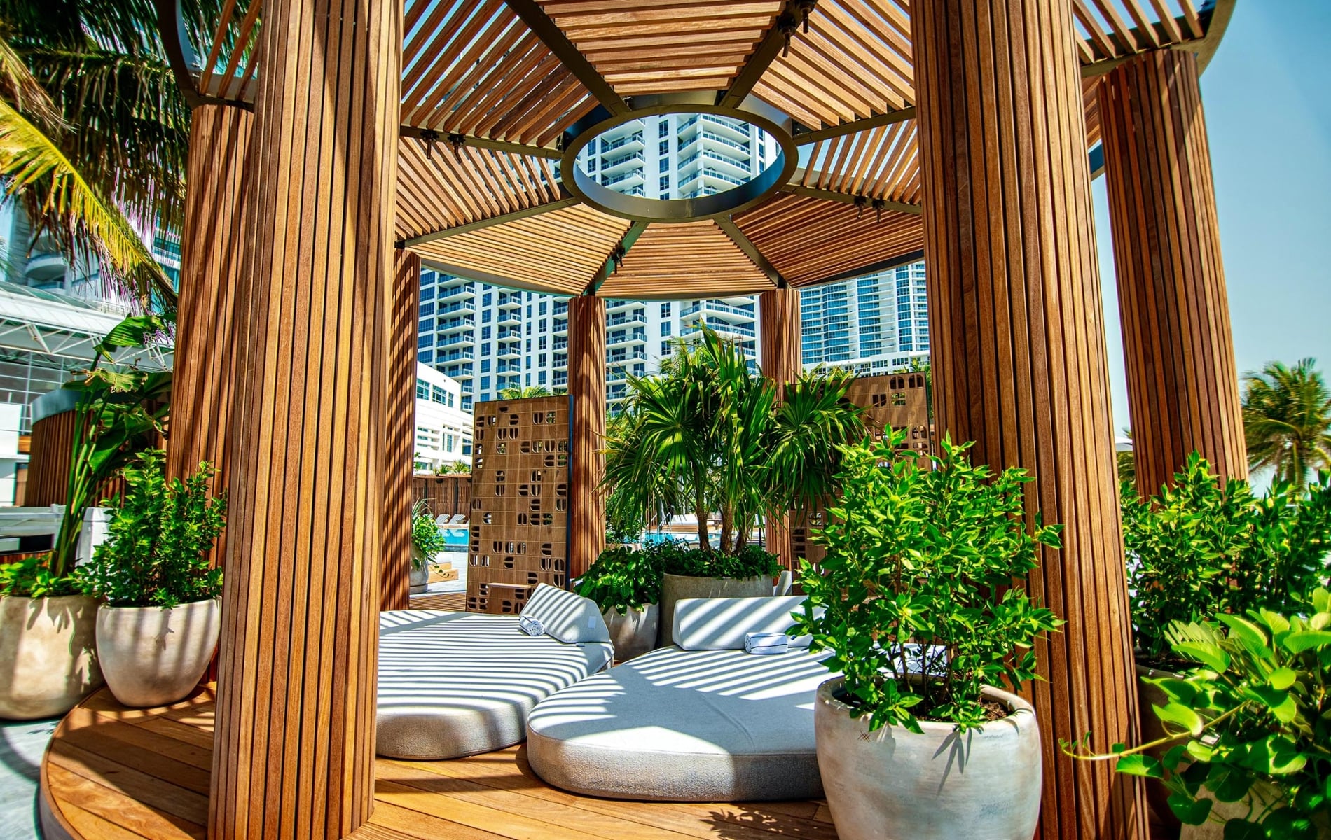 Infinity Pool Daybeds with a wooden hexagonal pergola overtop