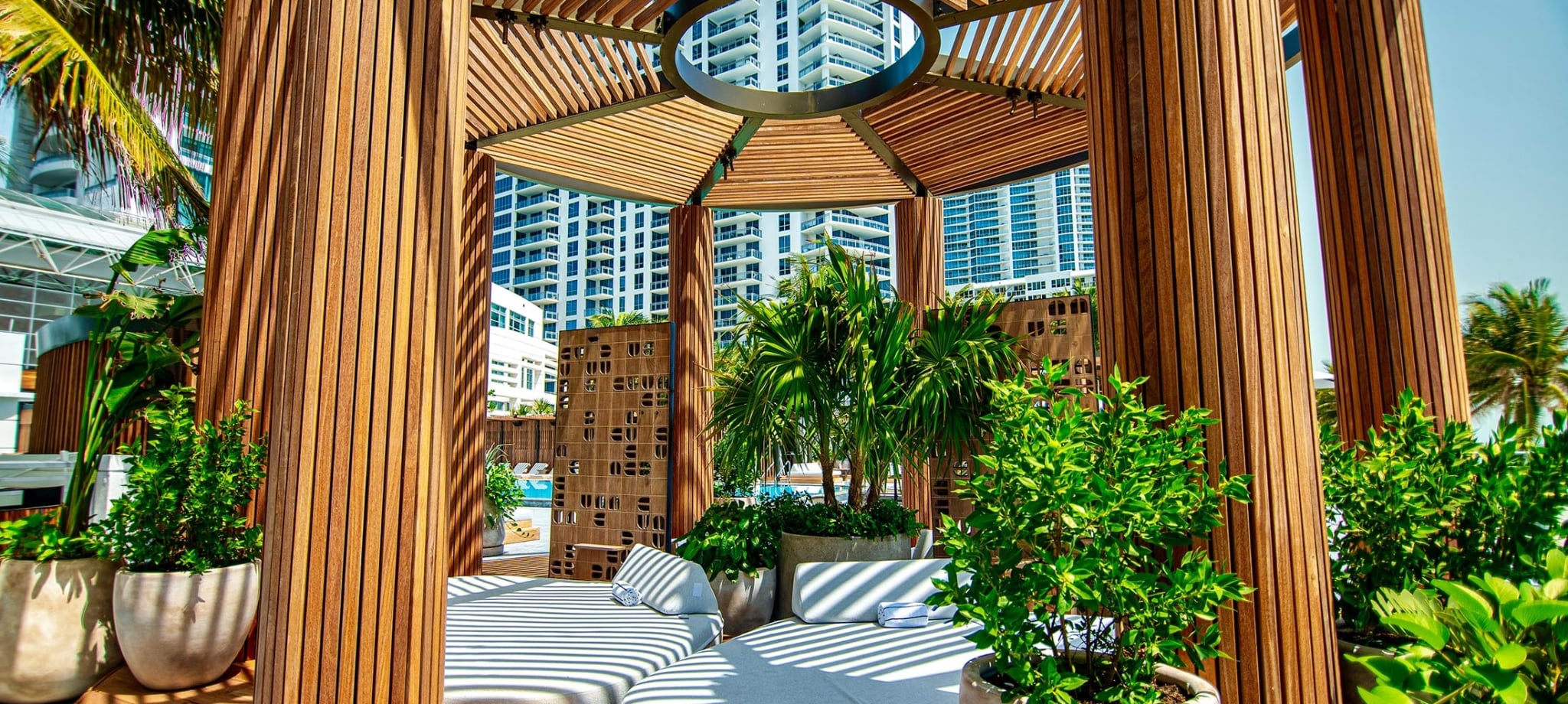 Infinity Pool Daybeds with a wooden hexagonal pergola overtop