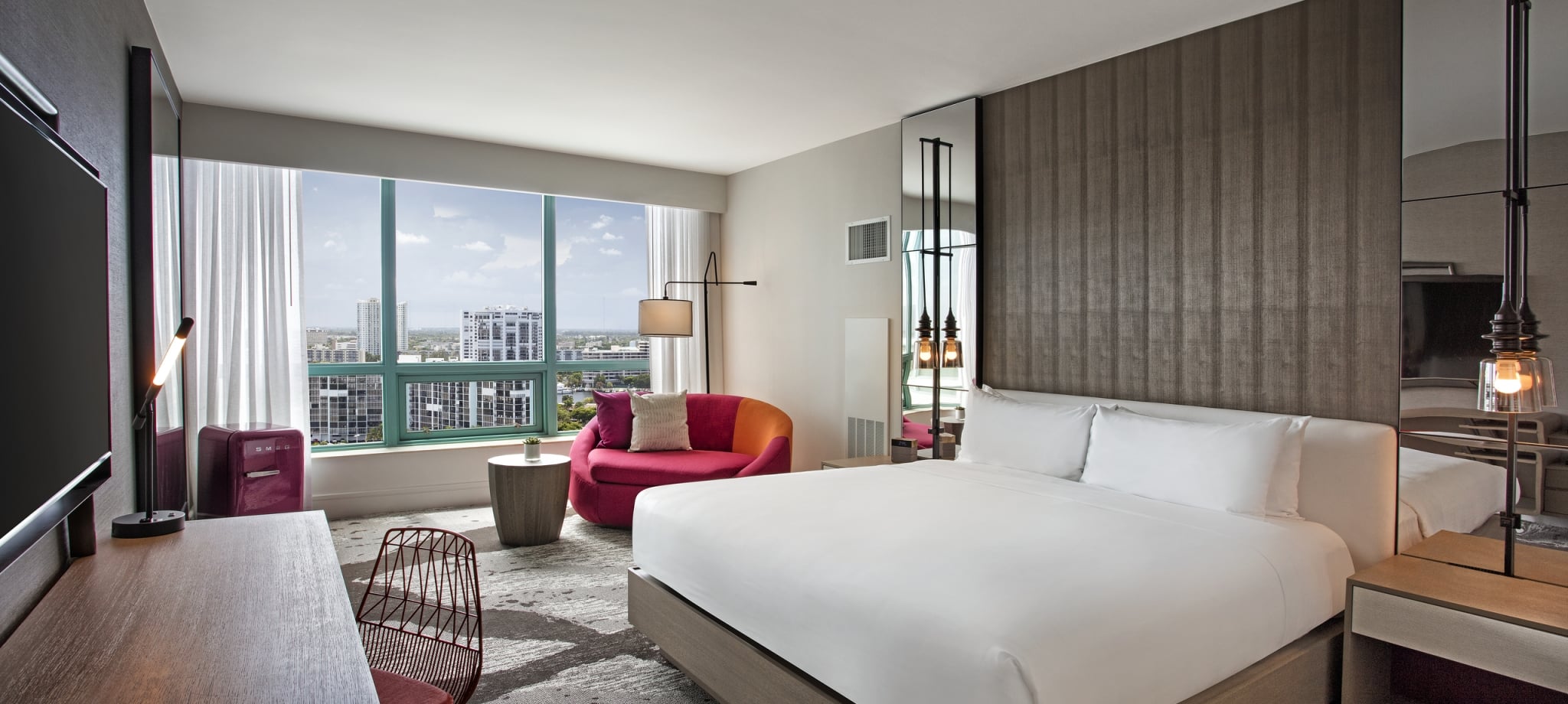 King Bed Intracoastal Guestroom with large windows overlooking the city