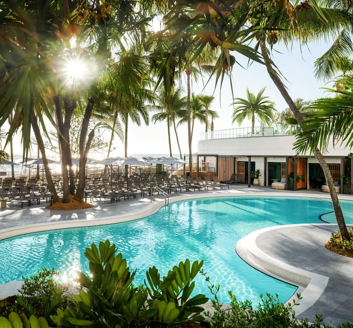 Lower lagoon outdoor pool featuring palm trees overhead and lounge chairs