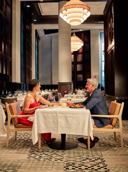 A well dressed couple seated for dinner
